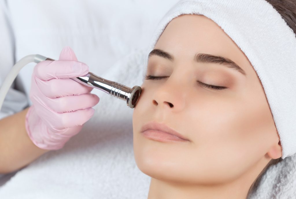 Microdermabrasion procedure of the facial skin during cosmetology and professional skin care.